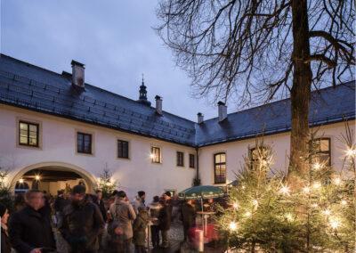 Innenhof mit beleuchteten Christbäumen beim Zeller Schloss Advent