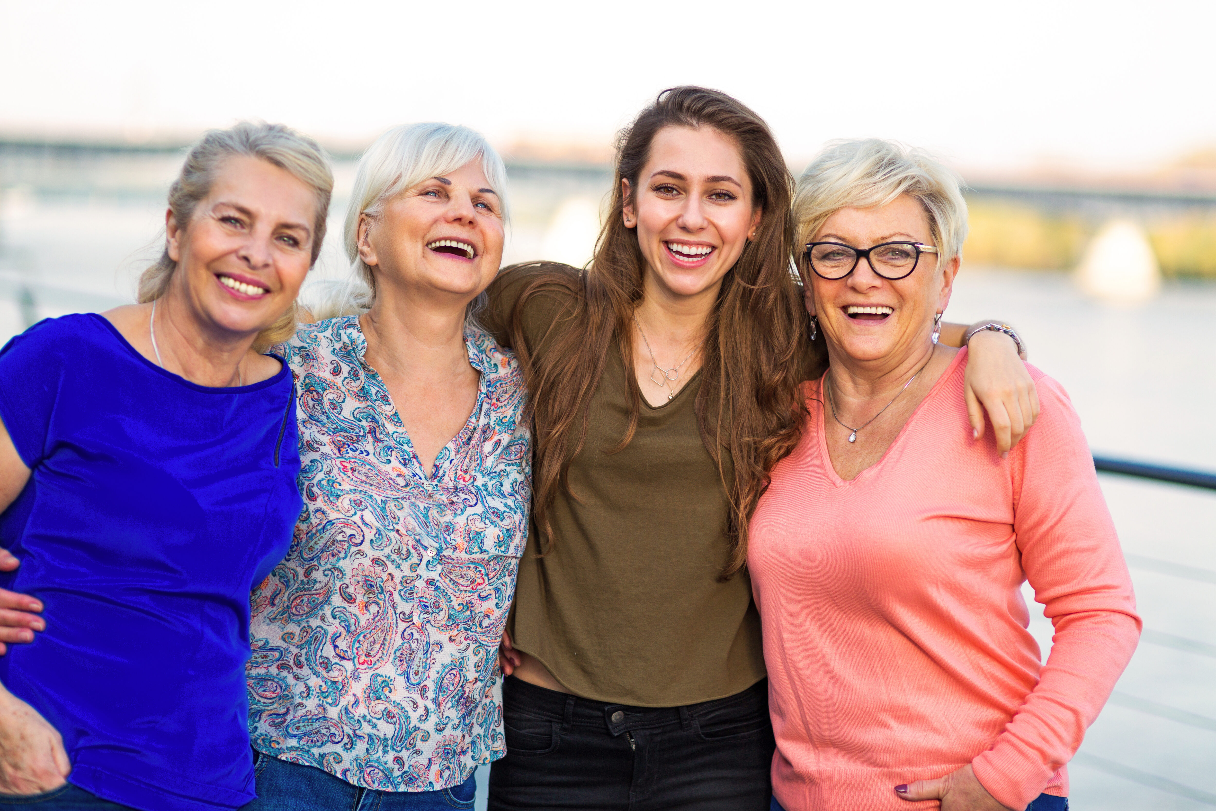 Frauen Wissen ist gesund_Shutterstock Gruppe von vier Frauen, die nebeneinander stehen und sich an den Schultern umarmen, lachend und fröhlich
